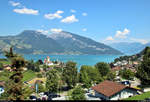 Der Thunersee bei heißem, nahezu wolkenlosem Sommerwetter mit Blick auf das Schloss Spiez (CH).