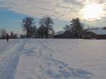 Joggerin in der Winterlandschaft, und die Sonne kmpft gegen das dichte Wolkenband ; 130119