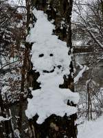 Schneemännchenfigur hat sich an einem Baumstamm gebildet; 130119