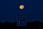 Vollmond über dem Richtungsschild an der A 20.