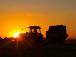 Den schnen Sonnenuntergang kann dieser Landwirt in Aachen am 21.08.2010 nicht geniessen, er muss noch das Stroh auf dem Feld pressen um es trocken in die Scheune zu bekommen.