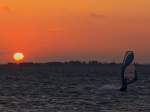 Surfer vor einem beeindruckendem Sonnenuntergang am Strand von Albertdorf auf Fehmarn im Mai 2010.