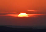 Langsam verschwindende Sonne hinter Dunst und Wolken am Horizont - 31.03.2021