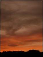 Ein Fallschirmspringer landet im Abendrot auf dem Flugfeld von Noertrange.