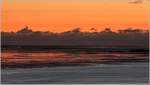 Abendstimmung an der Wesermündung bei Ebbe. Hinter dem Licht des Leuchtturms Wangerooge erhebt sich eine Wolkenwand aus dem Meer. Bremerhaven, 03.08.2020 gegen 22:20 Uhr.