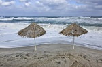 Sonnenschirme am Strand vor Geranie auf Kreta. Aufnahme: 18. Oktober 2016.