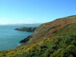 Felsen mwenkotbesudelt, die Luft seemwenzerkreischt, der Himmel in der Ferne wolkengeschmckt, die Irische See ruhig; nicht nur Wales und England weiter weg als der Horizont, auch Dublin scheint in