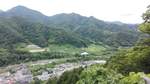 Ausblick auf das Bergpanorama vom Aussichtspunkt der Tempelanlage in Yamadera in Japan. Im Tal sind der Bahnhof von Yamadera und der kleine Ort zu sehen. Foto vom 05.07.2019.