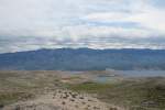 Helles Gestein mit nur wenigen Pflanzen bedeckt einen Teil der Insel Rab, vor allem im Sden. Die Berge im Hintergrund gehren zum Festland. 30.05.2010.