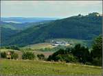 Auf diesem Bild wird die gewhnliche Perspektive, die wir als Bahnfotografen von dieser Landschaft haben, auf den Kopf gestellt. Links unten im Tal befindet sich die Haltestelle Goebelsmhle, das groe landwirtschaftliche Anwesen ist der  Fitschterhaff  und dieser befindet sich genau ber dem Portal des gleichnamigen Tunnels und man sieht auerdem, dass die Burg Bourscheid nicht auf der hchsten Erhebung dieser Region liegt. Das Bild wurde am 01.08.2010 in Schlindermanderscheid aufgenommen. (Jeanny) 