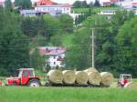 Eine satte grne Wiese, jedoch der Landwirt der Nebenparzelle ist emsig mit der  Heuernte (Rundballen) beschftigt, um diese noch vor dem herannahenden Gewitter einzubringen! 070527