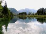 Almsee im oberösterreichischen Teil des Salzkammergutes, bietet am Südufer eine wolkenverhangene Spiegelung; 140809