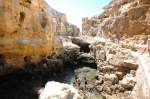 Algar Seco an der Algarveküste. Aufnahme: Juli 2010. Wind und Wetter haben im Laufe von Jahrhunderten diese Landschaft aus Felssäulen, Plateaus und Höhlen geformt. Die Gezeiten tun ein übrigens, um diesen Ort gespenstisch erscheinen zu lassen; ein kleiner  Bergsee  steigt und fällt mit Ebbe und Flut, das Meer gurgelt aus verwinkelten Höhlen und Spalten; die Farbe des Kalksteins ändert sich mit dem Sonnenlicht und dem Sonnenstand.