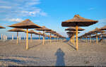 In Reih und Glied stehen noch die hölzernen  Sonnenschirme  am Strand von Mamaia (RO) am Schwarzen Meer.