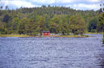 Der See Hjortesjön von der Eisenbahn Åseda-Virserum aus gesehen. Die Eisenbahnstrecke wurde 1984 stillgelegt. Heute kann man die Strecke mit Fahrraddräsinen befahren. Aufnahme: 18. Juli 2017.