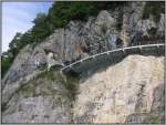 Die gleiche Strae in den Felsen oberhalb des Thuner Sees wie auf dem vorherigen Bild, allerdings an anderer Stelle und von einen Schiff aus aufgenommen.