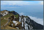 Richtung Norden fällt der Rigi steil ab. Im Tal ist, etwas verborgen von Wolken, der Vierwaldstätter See zu sehen. (Rigi Kulm, 23.04.2022)