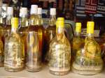 Eine  Spezialitt  wird auf der laotischen Insel im Mekong angeboten: Snake-Whisky. Wer mchte, kann diesen auch verkstigen. Aus einem groen Bottich werden an Interessenten Proben gereicht. (April 2006)