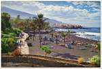 Strand aus Lava-Asche, Puerto de la Cruz auf der Kanareninsel Teneriffa. Im Hintergrund der Ort Punta Brava. November 2017.