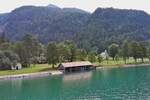 Schifffahrt über den Achensee, kurz vor dem Anleger Gaisalm liegt dieses Bootshaus am Ufer des Achensees.