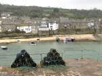 Sicht von der Hafenmauer auf Mousehole. Die sauber gestapelten Fischerkrbe sind bereit fr den nchsten Fang.
(April 2008)