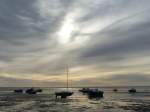 Ebbe, zarte Bewölkung und Sonnenstrahlen - dazu die Boote auf dem Watt.