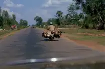 Kurz vor Erreichen von Siem Reap war die Strasse asphaltiert. Hier ein Motorrad beladen mit viel Gefl�gel vor dem Toyota, mit dem ich von Poipet nach Siem Riep fuhr, mit Rechtssteuerung, also aus Thailand, - in Kambodscha herrscht Rechtsverkehr und einer gesprungenen Windschutzscheibe. (Mai 2006)