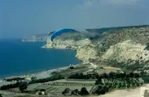 Ein schmeler Streifen Strand, dahinter etwas landwirtschaftlich genutzte Fl�che bevor die Landschaft karg ansteigt hinauf nach Kourion an der Westk�ste Zyperns. Hier nutzen Drachenflieger die Thermik zum gleiten. (November 1996)