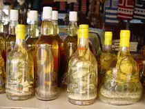 Eine  Spezialit�t  wird auf der laotischen Insel im Mekong angeboten: Snake-Whisky. Wer m�chte, kann diesen auch verk�stigen. Aus einem gro�en Bottich werden an Interessenten Proben gereicht. (April 2006)