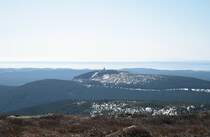Vorfr�hling auf dem Brocken: Blick um die Mittagszeit des 25.03.2012 vom Gipfelrundweg des Brocken Richtung S�den �ber die z.T. noch von Schnee bedeckten Bergr�cken des K�nigsbergs und des Wurmbergs, den S�dharz, die Hainleite bis zum �ber 100 km entfernten Mittelgebirge Th�ringer Wald, der unter dem Horizont aus einem Nebelmeer herausragt: Rechts erkennt man deutlich den Gro�en Inselsberg.