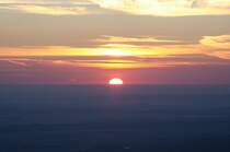 Sonnenaufgang auf dem Brocken; die Sonne hat sich zur H�lfte �ber die Erdoberfl�che gehoben. Blick am fr�hen Morgen des 28.08.2012 von der Treppe des Brockenhauses �ber das nord�stliche Harzvorland