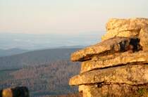 Die  Teufelskanzel  auf dem Brocken im ersten Morgensonnenlicht; Blick am fr�hen Morgen des 28.08.2012 vom Gipfelrundweg Richtung S�dwesten �ber den sich gro�fl�chig erneuernden Wald der Achtermannsh�he, den Rehberg, Berge des S�dharzes bis zum D�n, Eichsfeld und dem  Hohen Mei�ner  in den Kasseler Bergen (rechts am Horizont direkt neben dem Felsturm).