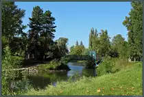 Auf einer kleinen Insel im Adolf-Mittag-See befindet sich ein Bootsverleih. Im Hintergrund der Magdeburger Dom. (Rotehornpark Magdeburg, 03.10.2013)