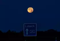 Vollmond über dem Richtungsschild an der A 20. - 28.09.2015