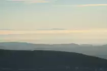 Abendstimmung am 05.12.2016 auf dem Brocken; über dem dunklen Bergrücken des Wurmbergs und südharzer Bergen ragt in der Ferne am Horizont der  Große Inselsberg , der bekannteste Gipfel des Thüringer Walds, ca. 115 km entfernt, aus einem Nebelmeer...