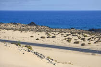 Fuerteventura in Spanien - Eine Strasse wurde mitten durch die Wanderdünen von Corralejo gebaut, die von Puerto del Rosario an der Ostküste Fuerteventuras entlang bis nach Corralejo führt.

Aufnahme: 18. Oktober 2017.